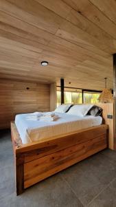Casa Contenedor - Bermejo Mendoza في غوايمالين: غرفة نوم مع سرير خشبي كبير في غرفة