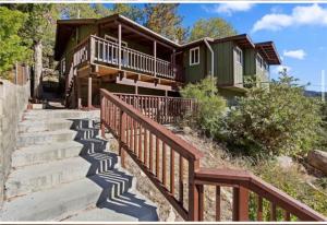 a house with stairs leading up to a house at Modern hilltop cabin, 3 miles from Snow Valley in Arrowbear Lake