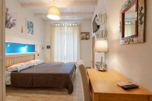 een slaapkamer met een tafel, een bed en een bureau bij Il Cagliarese B&B in Cagliari