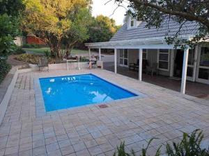 uma piscina em frente a uma casa em Stylish house/Heated swimming pool-5min to Beach em Wilderness