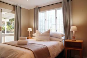a bedroom with a bed with pillows and a window at Stylish house/Heated swimming pool-5min to Beach in Wilderness