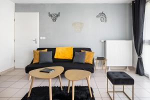 uma sala de estar com um sofá preto e duas mesas em Pure Gold - Casa Vostra - Annemasse Proche Chateau Rouge em Annemasse