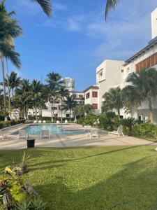 a swimming pool in a park with palm trees at Casa Blanca: Frente al mar in Same