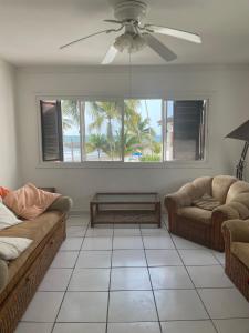a living room with two couches and a ceiling fan at Casa Blanca: Frente al mar in Same