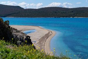 una playa con agua azul y montañas de fondo en O Molos en Marmarion