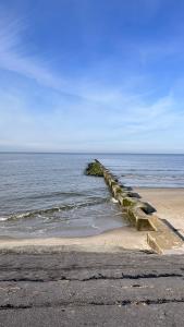 a pier stretches out into the ocean on a beach at Huus Borkum in Borkum