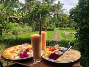 a table with a plate of food and a drink at Mu Homestay in Tetebatu