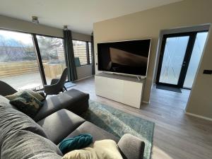 uma sala de estar com um sofá e uma grande televisão de ecrã plano em Keflavik Apartments 101 em Keflavík