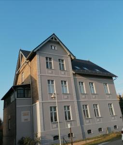 a large gray building with a gambrel roof at Gästewohnung Schwanenteich in Ueckermünde