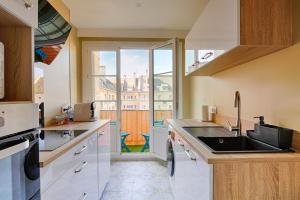 a kitchen with a sink and a large window at Le "Cassiopée" appartement neuf sur le port de Caen in Caen