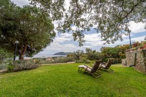 帕勒雍提費基翁的住宿－Villa Elia Kavala - Mediterranean Holiday Villa，两把椅子坐在院子里的草地上
