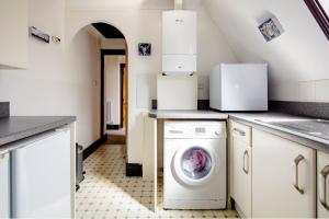uma cozinha com uma máquina de lavar roupa em Spacious Room 2 mins from station em Londres
