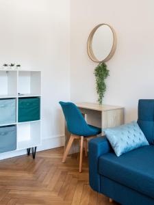 sala de estar con sofá azul y espejo en Jungle Paradise - Casa Vostra - Gaillard proche tram-frontière, en Gaillard