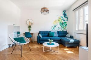 - un salon avec un canapé bleu et une table dans l'établissement Jungle Paradise - Casa Vostra - Gaillard proche tram-frontière, à Gaillard