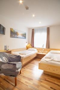 ein Zimmer mit 4 Betten und einem Sofa darin in der Unterkunft Hotel Gisela in Kufstein