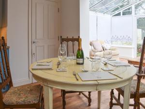 una mesa con copas y una botella de vino en Garden Cottage 1 - Uk42881, en Liphook