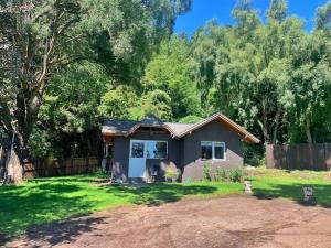 a small house in a yard with a fence at Casa La Quinta - Tiny House in San Carlos de Bariloche