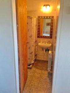 y baño con ducha, lavabo y espejo. en Casa La Quinta - Tiny House en San Carlos de Bariloche