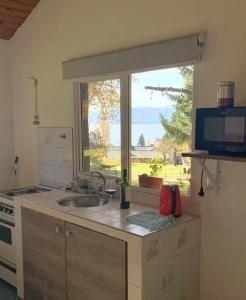 a kitchen with a sink and a large window at Casa La Quinta - Tiny House in San Carlos de Bariloche
