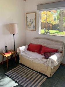 Un dormitorio con una cama con una guitarra. en Casa La Quinta - Tiny House en San Carlos de Bariloche