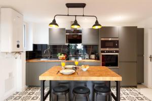 a kitchen with a wooden table and some chairs at Cyclades YourHostHelper in Cannes