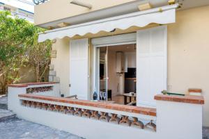 a white house with a row of brick seats at Cyclades YourHostHelper in Cannes