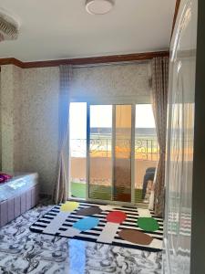 a bedroom with a view of the beach through a window at Typique appartement avec vue sur la Mer Rouge in Quseir