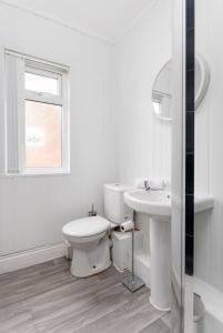 a white bathroom with a toilet and a sink at Host Liverpool - Anfield's Comfy Corner, Stylish & Fam-Friendly in Liverpool