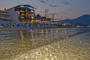 a beach at night with chairs and a bar at Blue Sea Beach Hotel in Skala Potamias