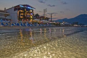 una spiaggia notturna con sedie e un bar di Blue Sea Beach Hotel a Skala Potamias
