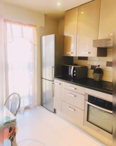 a kitchen with a stainless steel refrigerator and a window at Luxurious appartment near the airport Nice in Nice