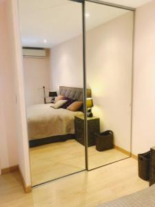 1 dormitorio con cama y espejo grande en Luxurious appartment near the airport Nice en Niza