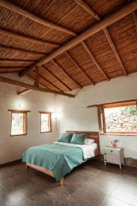 1 dormitorio con cama y techo de madera en Casa Primitivo en Barichara