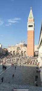 een groot plein met een klokkentoren en een gebouw bij MH2665 in Venetië