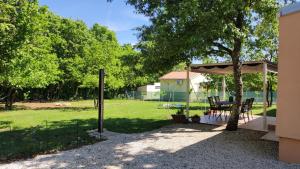 gazebo con tavolo da picnic sotto un albero di Tiny house Dora a Marčana