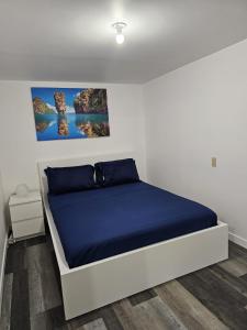 a bedroom with a bed with a blue bedspread at River Park South - 2 Bedroom Basement Suite in Winnipeg