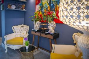 a room with two chairs and a table with vases at Boutique Hotel Ferrara in Ferrara
