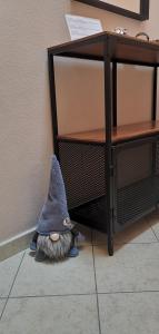 un chat avec un chapeau allongé sur le sol à côté d'une table dans l'établissement Appartamento En Mez al Paes, à Dimaro