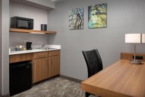 a kitchen with a desk and a table and a microwave at SpringHill Suites by Marriott Boise ParkCenter in Boise
