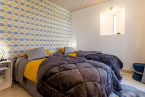 ein Schlafzimmer mit 2 Betten und einer geometrischen Wand in der Unterkunft Le grand clos, 3 étoiles in Pont-Saint-Martin
