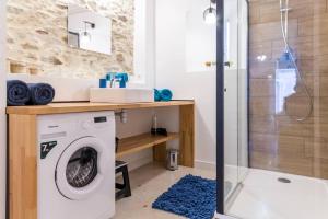 uma casa de banho com uma máquina de lavar roupa e um chuveiro em Le grand clos, 3 étoiles em Pont-Saint-Martin