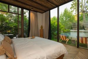 a bedroom with a large white bed and large windows at To Be Social House in Fethiye +193 photos
