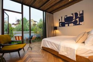 1 dormitorio con cama y ventana grande en To Be Social House, en Fethiye