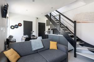a living room with a couch and a staircase at Life is music - Casa Vostra - Gaillard proche tramway-frontière in Gaillard