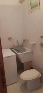 een witte badkamer met een toilet en een wastafel bij Casa vacanza spiaggia Praia in Favignana