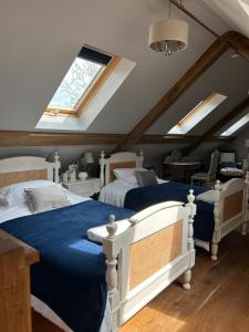 a attic bedroom with two beds and a window at Hideaway Barn Coltishall in Coltishall
