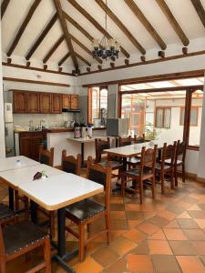eine Küche und ein Esszimmer mit Tischen und Stühlen in der Unterkunft Hotel Casa Campestre Villa Anita in Villa de Leyva