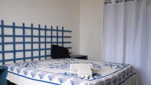 uma cama com um cobertor azul e branco e uma cadeira em MareDentro em Mazara del Vallo