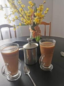 une table avec deux tasses de café sur une table dans l'établissement Zielony Zakątek Ciężkowice, à Ciężkowice