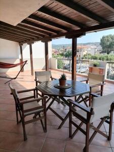 un patio avec une table et des chaises sur un porche dans l'établissement Afroditi's House, à Nikiti